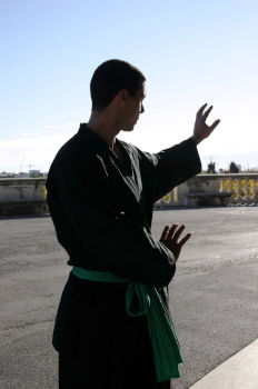 Enseignant dans une posture traditionnelle, les mains face au soleil